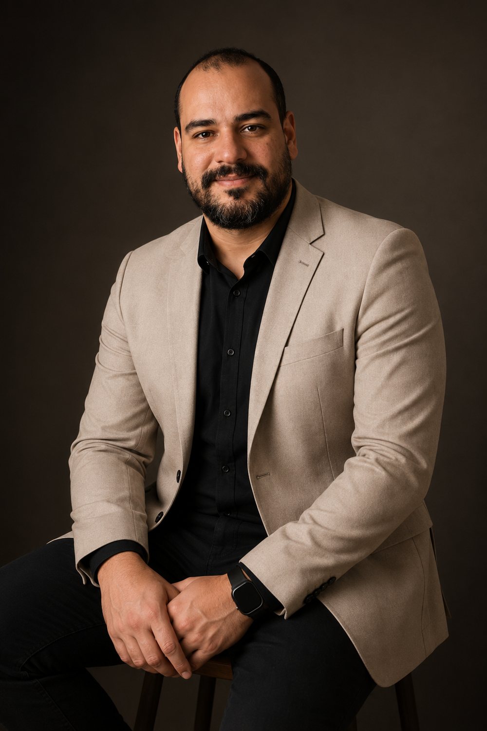 Guilherme Moraes, o Cara do ERP, sentado, de blazer bege e camisa preta